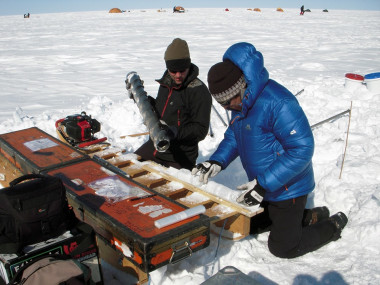 <p>Mike MacFerrin (izquierda) y Horst Machguth (derecha) analizan muestras de núcleos de hielo perforadas en la capa de hielo de Groenlandia en 2012. / © GEUS</p>
